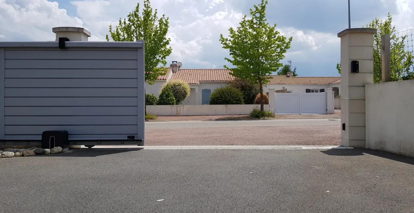 Une personne actionne un clavier de commande pour ouvrir un portail motorisé