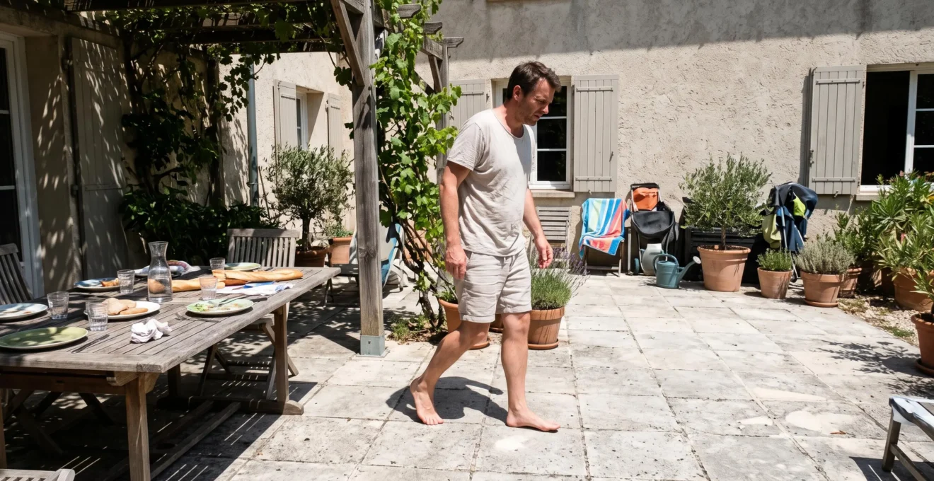 Une personne marche pieds nus sur une terrase carrelée en plein soleil de midi, réagissant à la chaleur du revêtement.